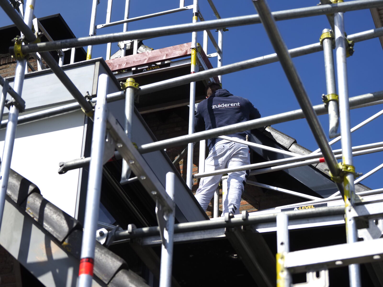 Werknemer van Zuiderent aan het buitenschilderen